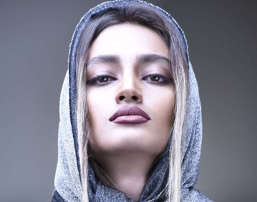 Beauty portrait of a woman in a silver knitted hood